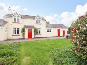 a house with red doors and a yard at Plas Cwtta in Clocaenog