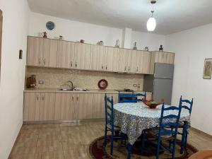 a kitchen with a table with blue chairs and a kitchen with cabinets at Countriside Holiday Villa 