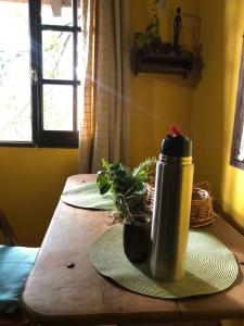 a wooden table with a thermos on top of it at Prana Eco hospedaje in Cordoba