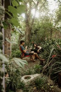 zwei Personen, die in einem Garten auf Stühlen sitzen in der Unterkunft Prana Eco hospedaje in Cordoba