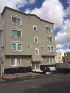 a large building with white windows on a street at Cheney Parkin in Taif