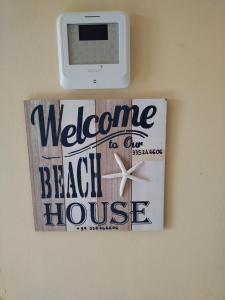 a welcome to our beach house sign on a wall at La Sorgente in Fontane Bianche