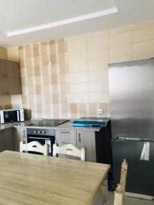 a kitchen with a stove and a counter with chairs at Belle appartement vue de mer in Zarzis