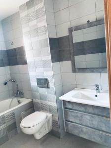 a bathroom with a toilet and a tub and a sink at Belle appartement vue de mer in Zarzis
