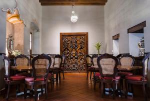 un comedor con mesas y sillas y una puerta en Hotel Boutique Naura Centro en Oaxaca de Juárez