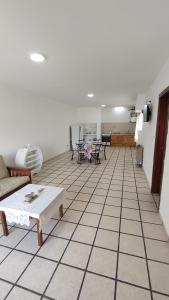 sala de estar con suelo de baldosa, sofá y mesas en Departamento en Necochea, en Necochea