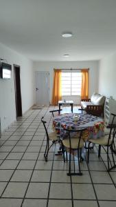 sala de estar con mesa y sillas en Departamento en Necochea, en Necochea