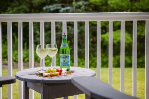 een tafel met twee glazen en een fles wijn bij Horseshoe Valley Suites - The Verdant in Shanty Bay