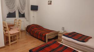 um quarto com duas camas e uma cadeira e uma janela em Dom Wczasowy Skałka em Żabnica