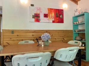 a dining room with a wooden table and white chairs at Cabañas Namoncahue in Pucón