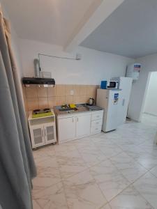 a kitchen with white appliances and a tiled floor at Complejo Las Flores a 5 min de Termas Chajari in Chajarí