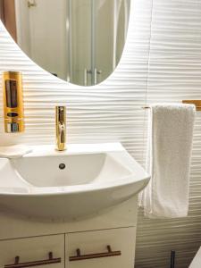 a white bathroom with a sink and a mirror at Art Place in Tomaszów Mazowiecki