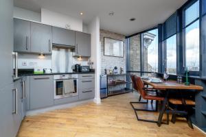 a kitchen with a wooden table and a dining room at Luxury Central London Penthouse in London