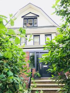 une maison blanche avec une porte et des escaliers noirs. dans l'établissement The Griffin B and B, Private two bedroom suite in Victorian Ditmas Park, à Brooklyn