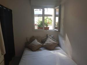 un letto in una camera con due finestre di La Ribasse en Provence a Venelles