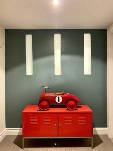 un coche de juguete rojo sentado en la parte superior de un armario rojo en The Griffin B and B, Private two bedroom suite in Victorian Ditmas Park, en Brooklyn