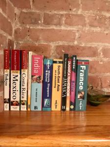 a row of books sitting on top of a shelf at The Griffin B and B, Private two bedroom suite in Victorian Ditmas Park in Brooklyn