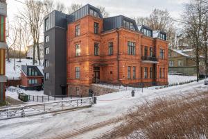Unique minicondo in Tartu's old town في تارتو: مبنى من الطوب الأحمر كبير في الثلج
