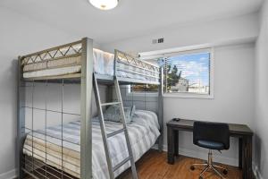 a bedroom with bunk beds and a desk and a chair at 5310 - Wright by the Beach by Resort Realty in Kill Devil Hills