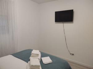 a room with a bed with a television on a wall at Anduriña in Vigo