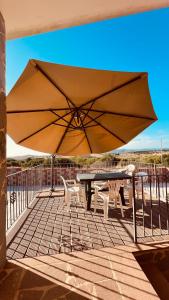 ein großer Sonnenschirm auf einer Terrasse mit einem Tisch und Stühlen in der Unterkunft Ferienhaus Bella Vista in Villarios