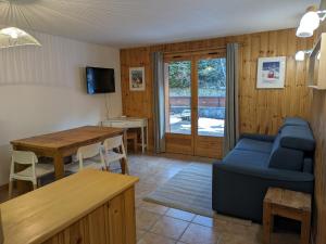 a living room with a blue couch and a table at Appartement Cosy avec Terrasse et Garage in Les Houches