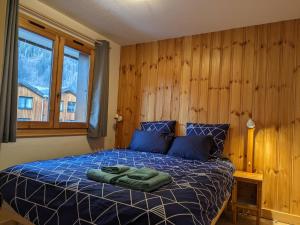 a bedroom with a bed with two green towels on it at Appartement Cosy avec Terrasse et Garage in Les Houches