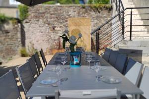 a table with glasses and a vase with flowers on it at GÎTE Les Cigognes N0ires in Dragey