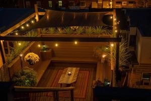 a patio with a wooden table and lights at Double Decker Roofdeck Gorgeous View in Passyunk in Philadelphia