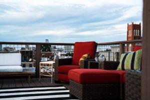 a balcony with a red couch and a table at Double Decker Roofdeck Gorgeous View in Passyunk in Philadelphia