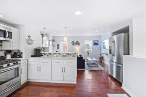 uma cozinha com armários brancos e electrodomésticos de aço inoxidável em Double Decker Roofdeck Gorgeous View in Passyunk em Filadélfia