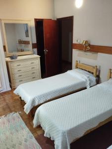 a bedroom with two beds and a dresser and a mirror at RESIDENCIA-UNIV in Ciudad del Este