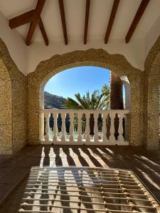 a room with a stone wall and a balcony with a view at Villa Víctor in Cómpeta