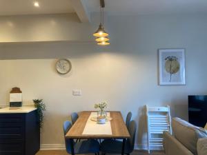 ベルファストにあるSmart 4K TVs in all bedrooms double vanity sinkのダイニングルーム(テーブル、壁掛け時計付)