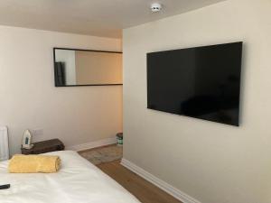 a bedroom with a large flat screen tv on the wall at Smart 4K TVs in all bedrooms double vanity sink in Belfast