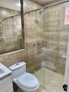 een badkamer met een toilet en een glazen douche bij paipa casa bonita in Paipa