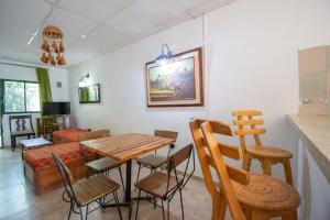 a dining room with a wooden table and chairs at Hostal Acuarius in Taganga