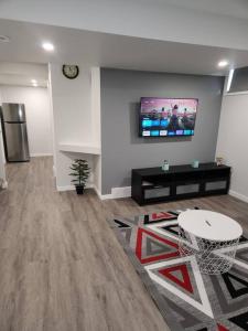 a living room with a tv on a wall at A Modern & Homely 1 BR Suite in Winnipeg