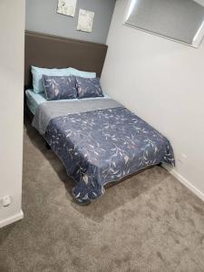 a bed with a blue comforter in a bedroom at A Modern & Homely 1 BR Suite in Winnipeg