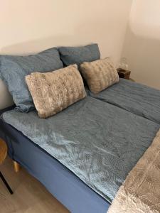 a blue couch with two pillows on top of it at Bed House By Me 2 in Vester-Skerninge