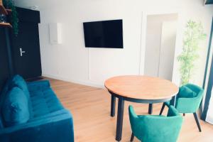 sala de estar con mesa, sillas y TV en Alison's Suite, en Thonon-les-Bains