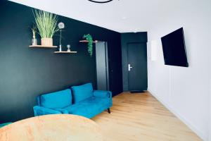 a living room with a blue couch and a table at Alison's Suite in Thonon-les-Bains