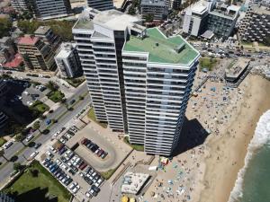 un edificio alto en una playa con multitud de gente en Disfruta Viña del Mar, en Viña del Mar