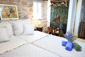 ein Schlafzimmer mit einem großen weißen Bett mit einem Gemälde an der Wand in der Unterkunft Peaceful & Secluded Retreat House Kod Kapetana Hvar III in Veliko Grablje