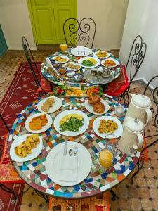 une table avec des assiettes de nourriture au-dessus dans l'établissement Riad Merzouga, à Fès