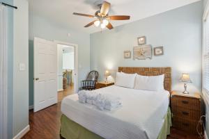 a bedroom with a bed and a ceiling fan at Sandy Cheeks in Folly Beach