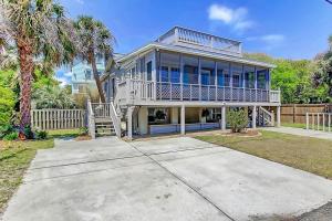 a large house with a porch and a balcony at Sandy Cheeks in Folly Beach