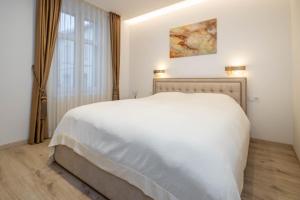 a bedroom with a white bed and a window at Brand new home in the center of the Old Town in Klaipėda