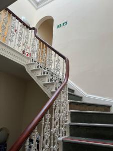 a spiral staircase in a home with a white ceiling at Botanic Avenue Hostel less than a mile from the City Centre in Belfast