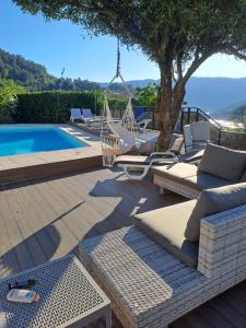 a patio with lounge chairs and a swimming pool at Casa das Pedras in Vieira do Minho